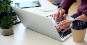 woman hands using laptop computer browsing internet typing emails sitting at table working on noteb